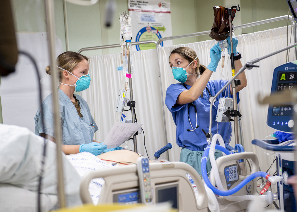 Lieutenant (junior grade) Kayla Marthy, from Long Island, New York (left), and Lieutenant (junior grade) Brianna Garcia, from St. Petersburg, Florida, treat a patient in the intensive care unit aboard the hospital ship USNS Mercy (T-AH 19), on April 13, 2020. U.S. Navy photo by Mass Communication Specialist 2nd Class Ryan M. Breeden.